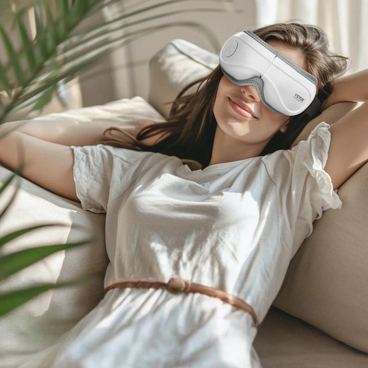 RelaxRiser™ DreamEyes Pro Heated Eye Massager worn by woman relaxing on sofa – perfect for relieving stress and eye fatigue